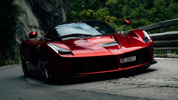 Red Ferrari F70 driving on a mountain road