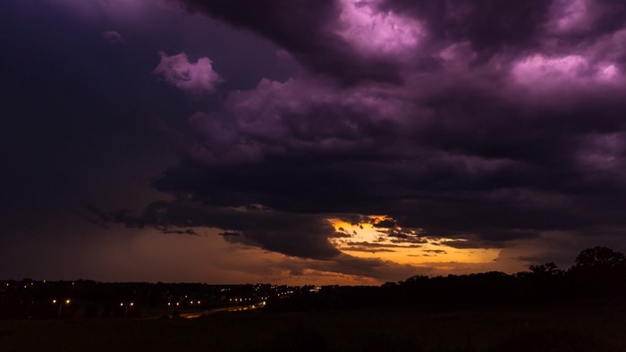 Dark purple clouds over a town at dusk