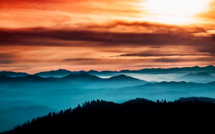 Mountain range at sunset with orange clouds