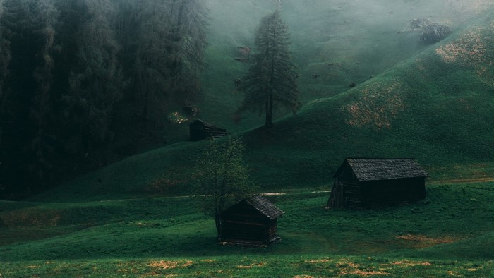 Wooden cabins in a misty mountain landscape