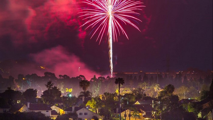 Fireworks over a suburban neighborhood at night