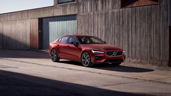 Red 2018 Volvo S60 parked outside a modern building