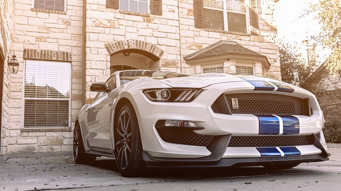 White Ford Mustang Shelby GT350 parked in front of a house