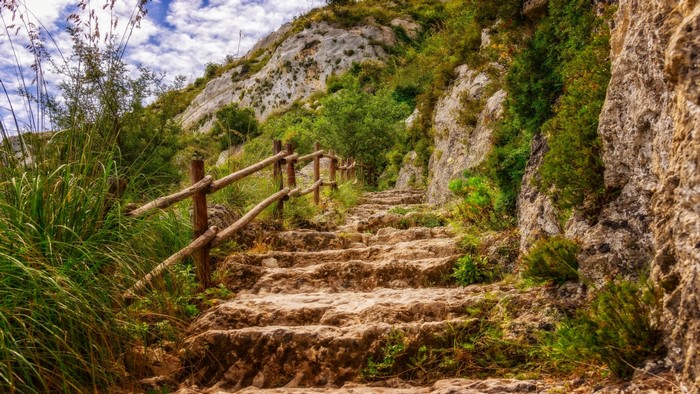 Stone steps on a mountain path with wooden railing