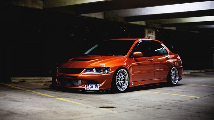 Orange Mitsubishi Lancer Evolution in parking garage
