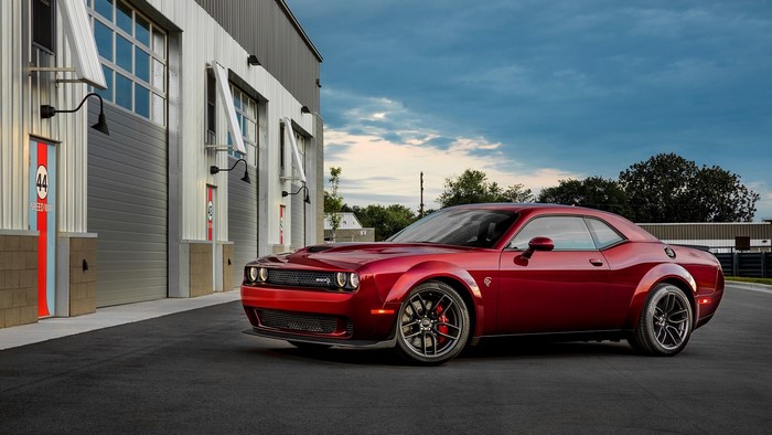 Red Dodge Challenger SRT Hellcat parked outside garage