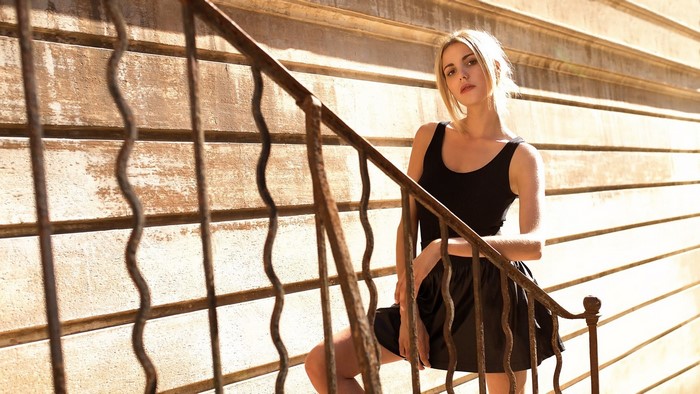 Young woman in black dress on stairs