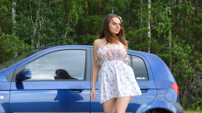 Girl Standing Next to Blue Car