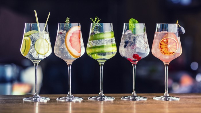Five garnished cocktails on a bar