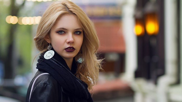 Blonde woman with dark lipstick and large earrings