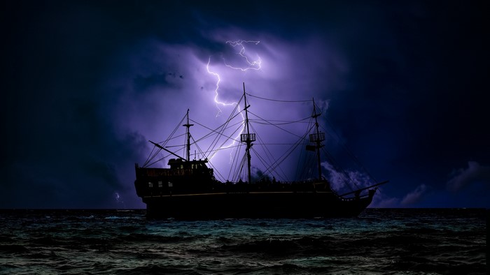 Silhouette of a pirate ship during a lightning storm