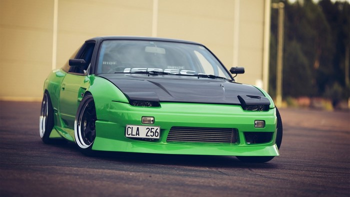 Green Nissan 240SX with black hood and Bride banner