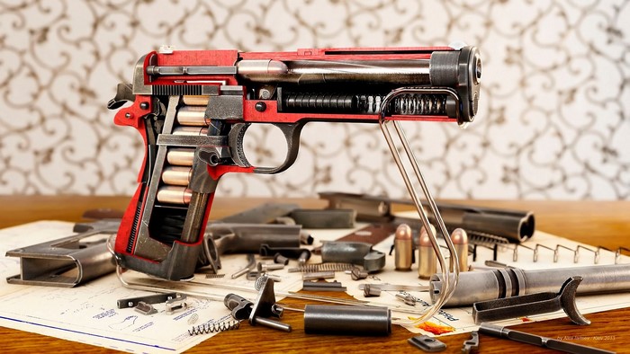 Cutaway Colt pistol with disassembled parts