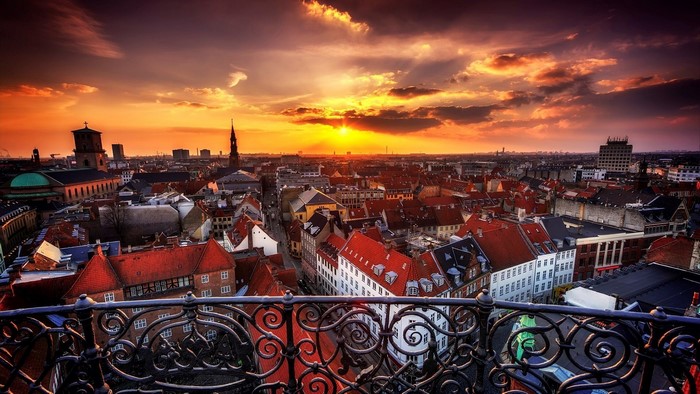 Copenhagen cityscape at sunset with ornate balcony
