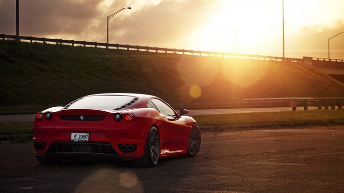 Red Ferrari F430 parked at sunset