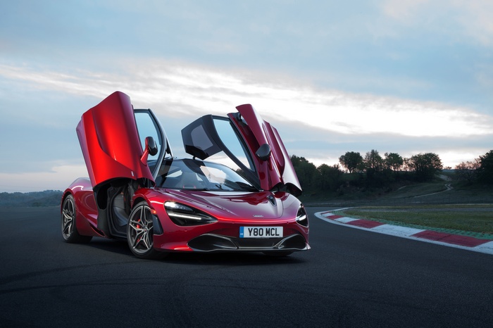 Red McLaren 720S with doors open on a race track
