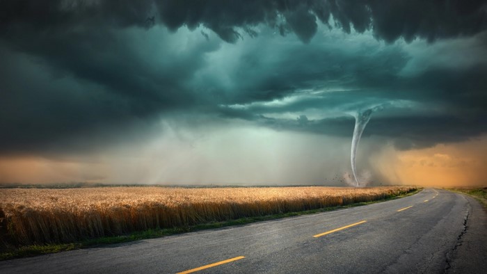 Tornado over a wheat field with a road