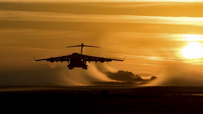Airplane taking off at sunset