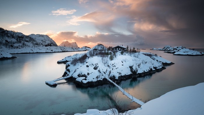 Snowy island with house and bridge in Norway