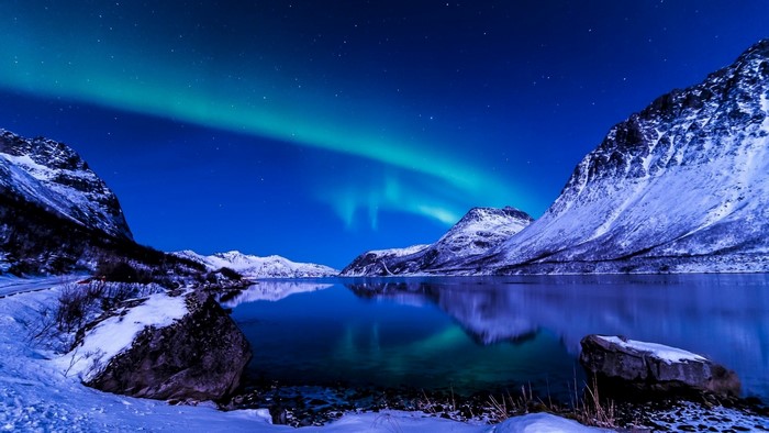 Aurora Borealis over Snowy Mountains and Lake