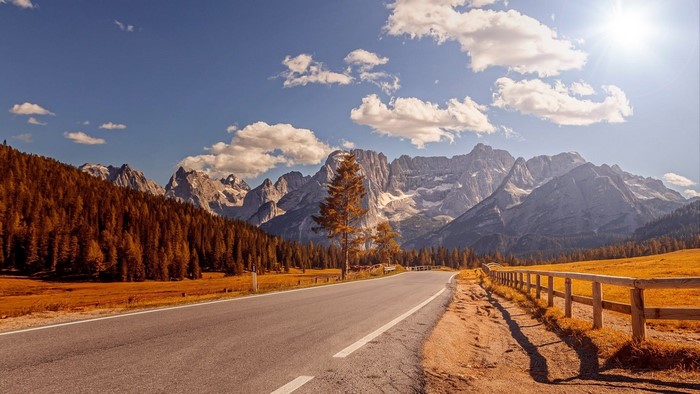 Road through the Alps with autumn trees and mountains
