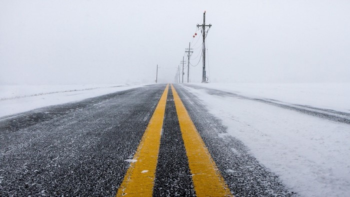 Road in a snowstorm with power lines