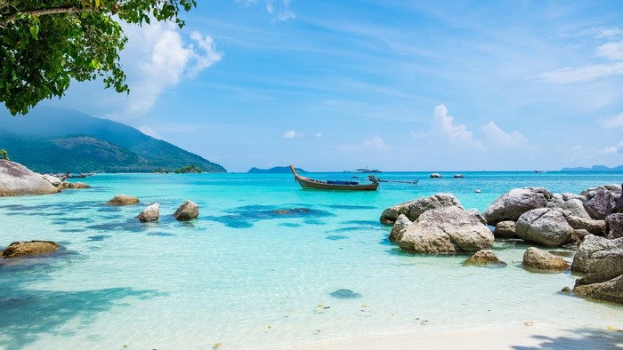 Tropical beach with turquoise water and mountains in Thailand