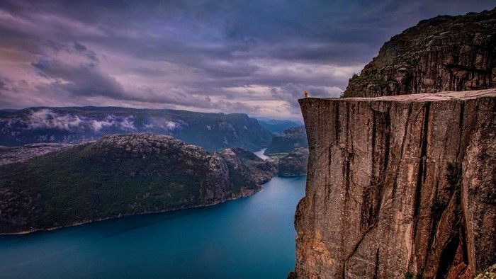 Person on Preikestolen cliff overlooking Lysefjord, Norway