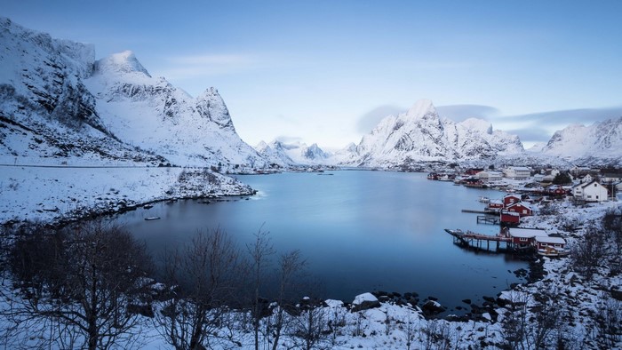 Snowy mountains and village by a lake in Norway