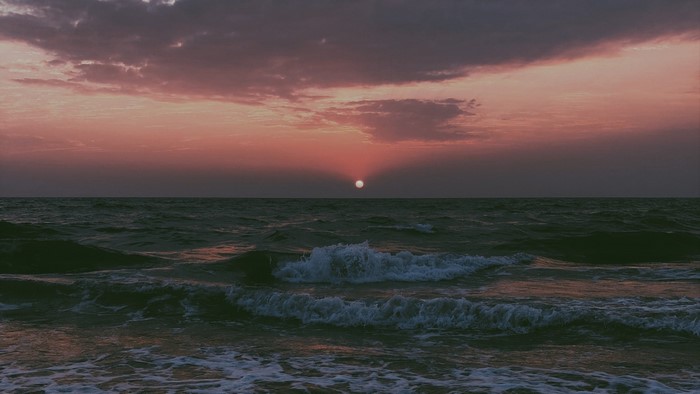 Sunset over the ocean with waves