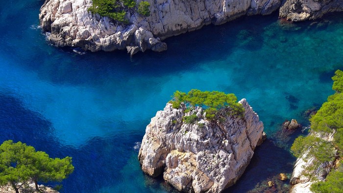 Turquoise water between rocky cliffs with green trees