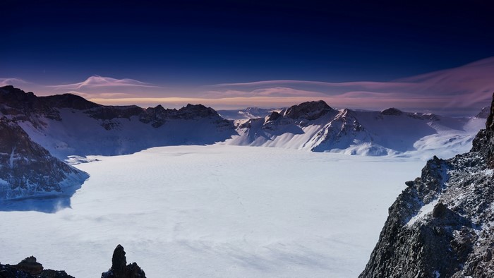Frozen mountain lake with snow-covered peaks