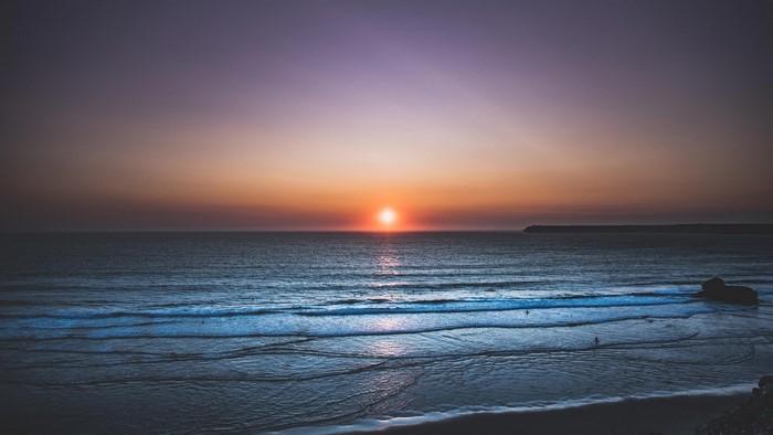 Sunset over the ocean with waves