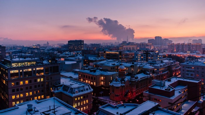 Cityscape at dusk with snow-covered roofs