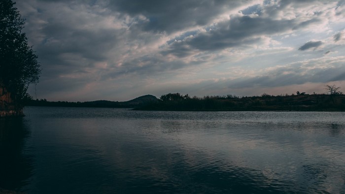 Lake with cloudy sky and distant hills