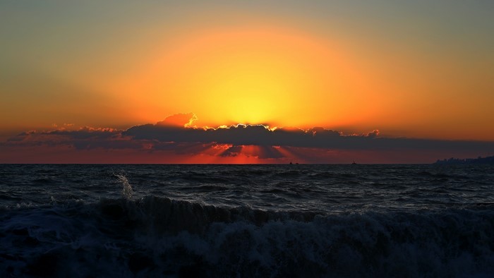Sunset over the sea with waves