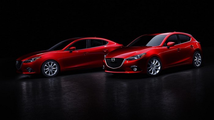Two red Mazda 3 cars on a dark background