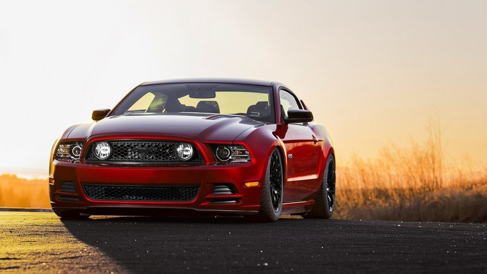 Red Ford Mustang parked on a road