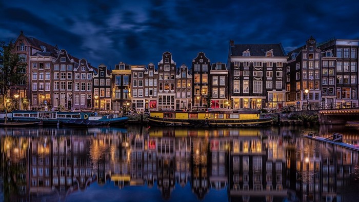 Amsterdam canal at night with reflections