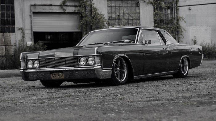 Lincoln Continental parked in front of an industrial building