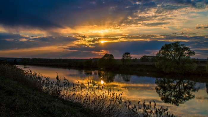 Sunset over a river with reflections