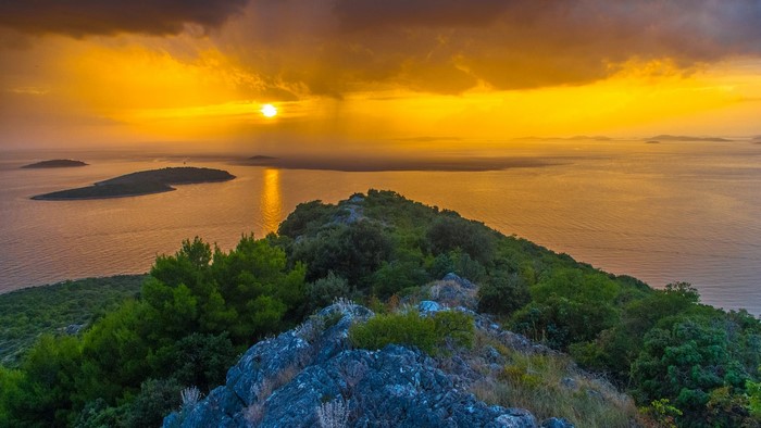 Sunset over islands and sea from a rocky peak