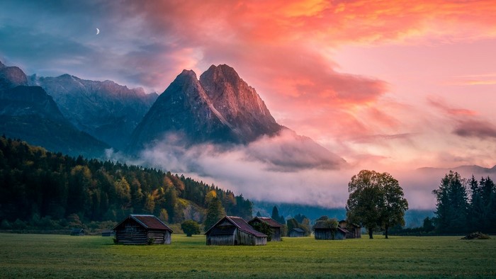 Mountain landscape with cabins at sunrise