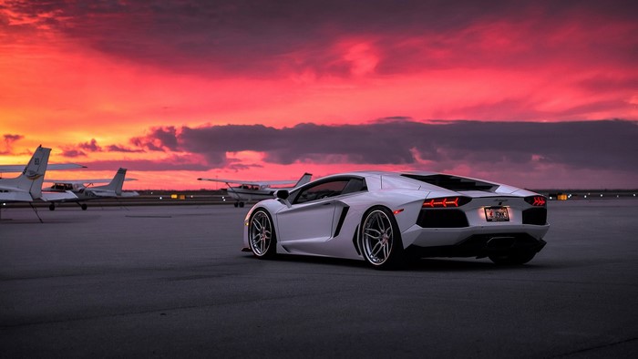 White Lamborghini Aventador LP 700-4 on tarmac at sunset