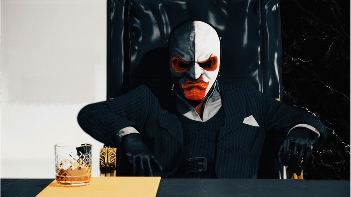 Payday 2 character in a mask sitting at a desk