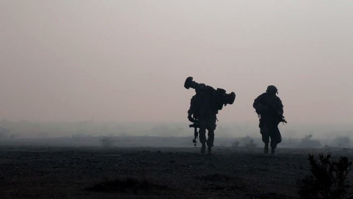 U.S. Army soldiers carrying weapons in hazy landscape