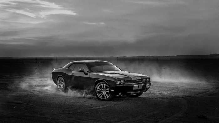 Black Dodge Challenger drifting in desert