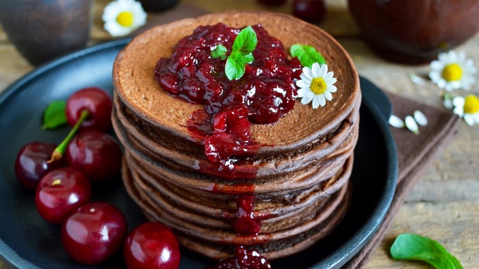 Chocolate pancakes with cherry jam and cherries