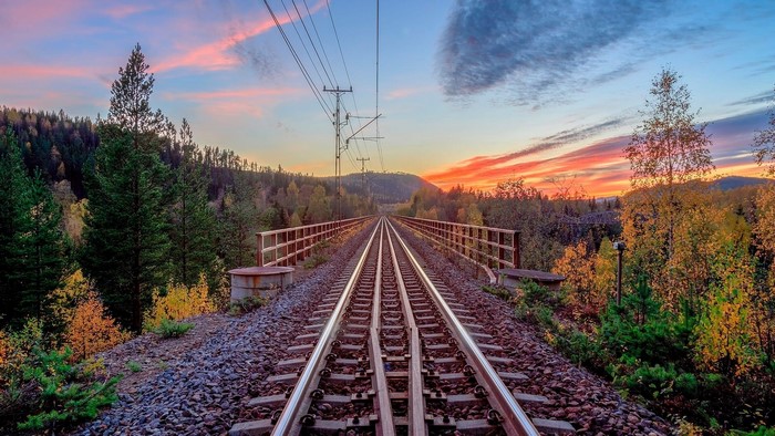 Train tracks on a bridge in Sweden at sunset
