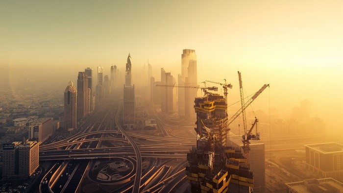 Dubai skyline with skyscrapers and construction cranes